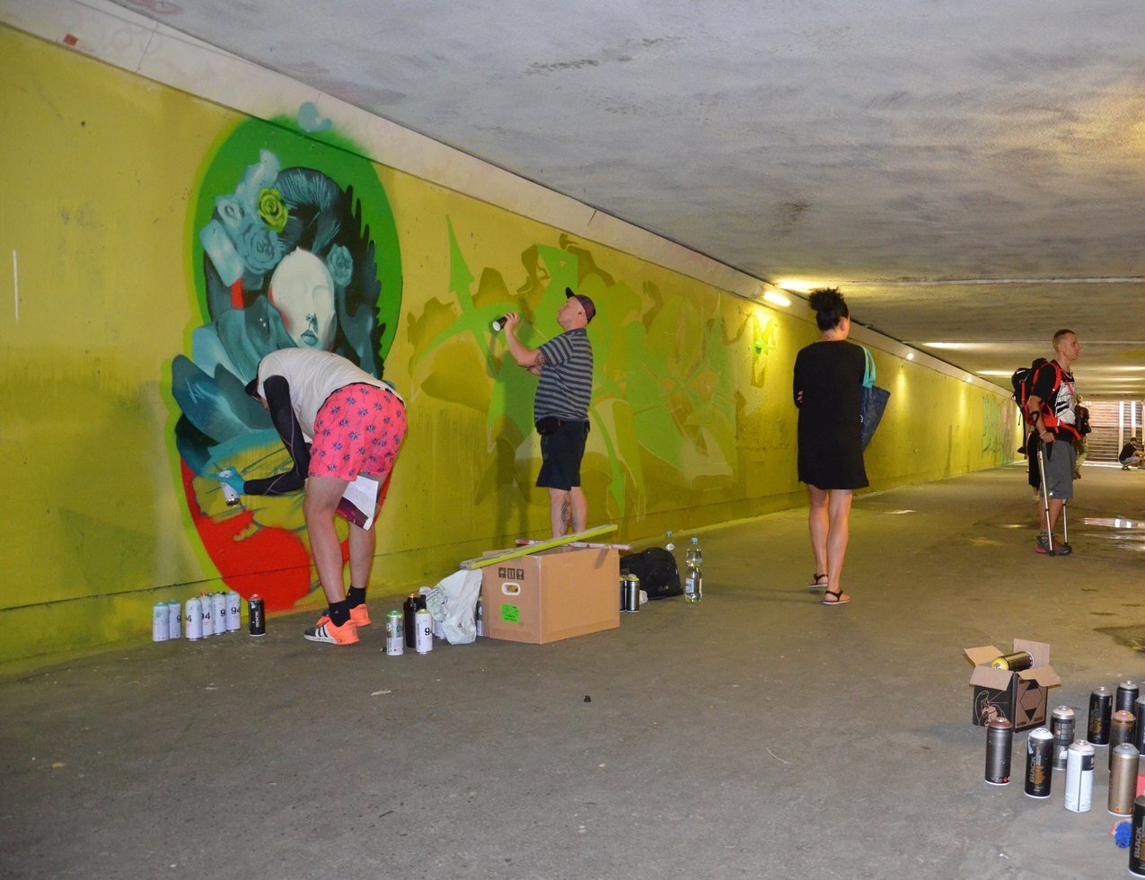 Artysci maluja mural w przejsciu pod torami laczacym ulice Wojewodzka i