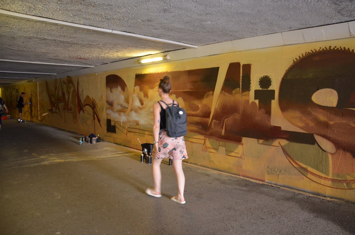 Artysci maluja mural w przejsciu pod torami laczacym ulice Wojewodzka i 1