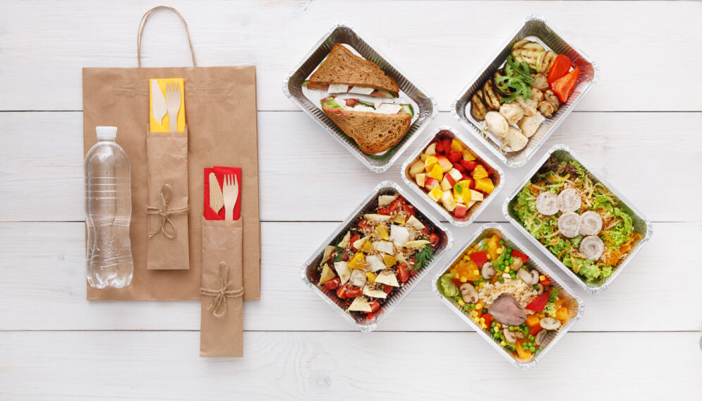 Healthy food take away boxes top view wooden table