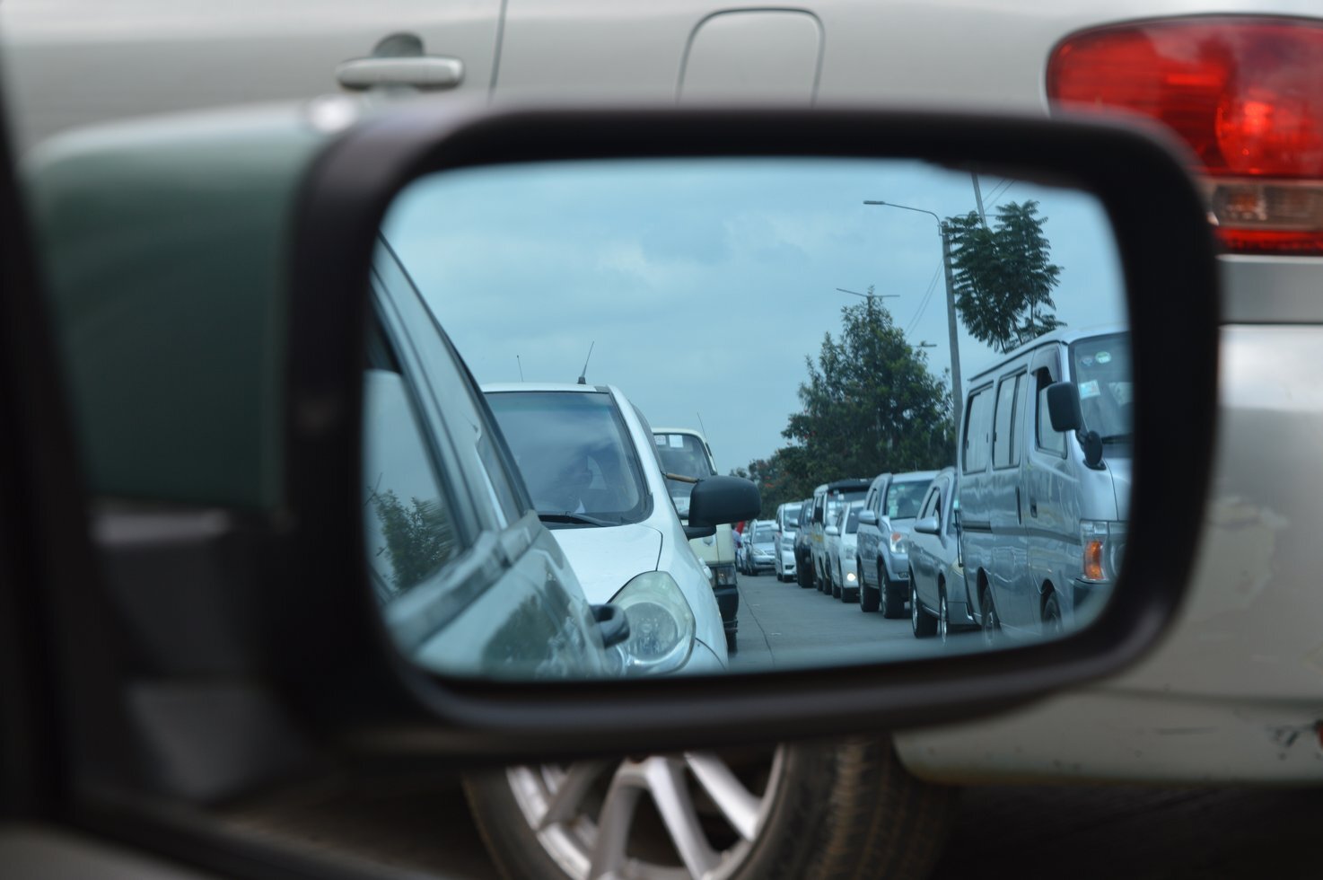 Car side mirror showing heavy traffic 191842