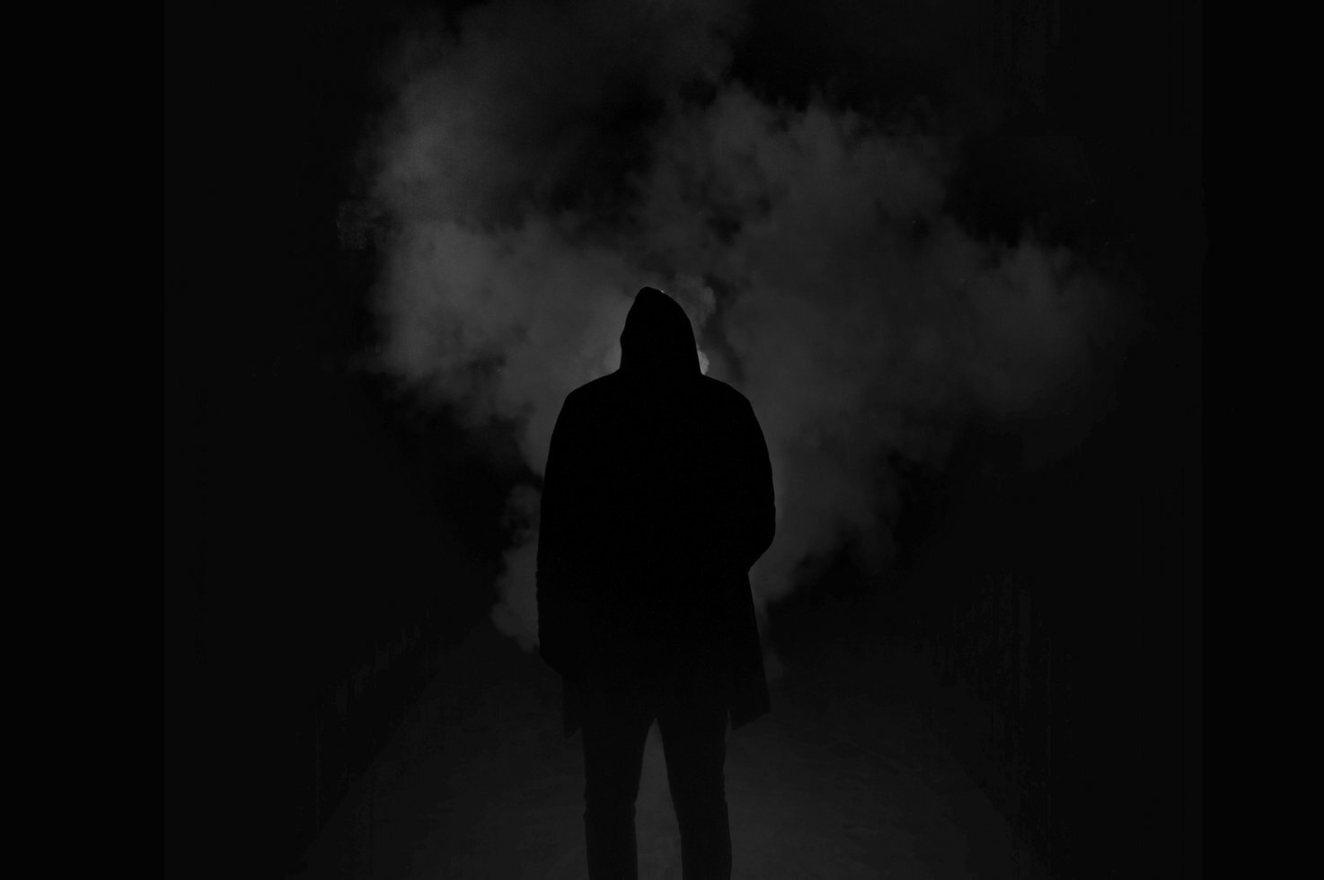 Silhouette of man standing against black and red background 333850